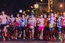 Runners start the Chiang Mai Marathon under a large inflatable arch at night.