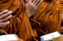 Monks in orange robes praying during Wan Awk Phansa festival in Chiang Mai.