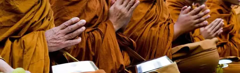 Monks in orange robes praying during Wan Awk Phansa festival in Chiang Mai.